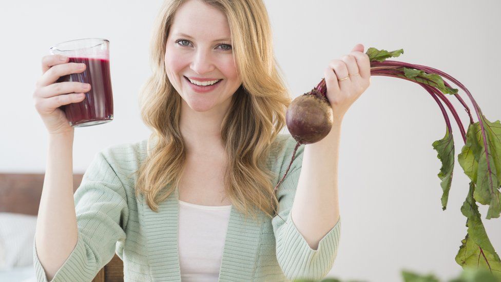 Woman holding a beetroot juice
