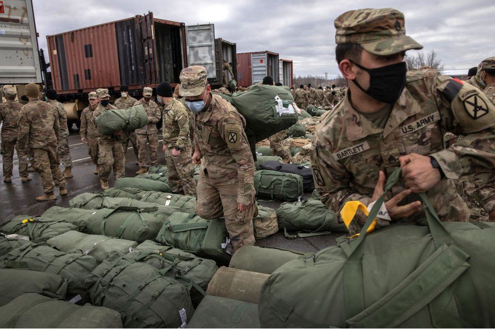 US Army soldiers retrieve their duffel bags after they returned home from a 9-month deployment to Afghanistan on December 10, 2020 at Fort Drum, New York.