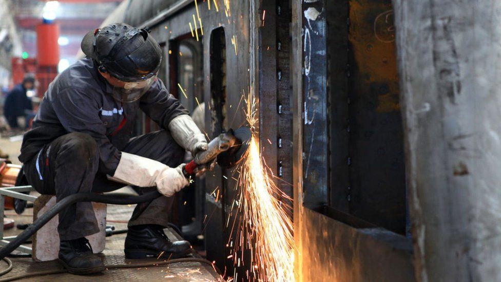 Chinese workers assembling new locomotive trains to be exported to Nigeria