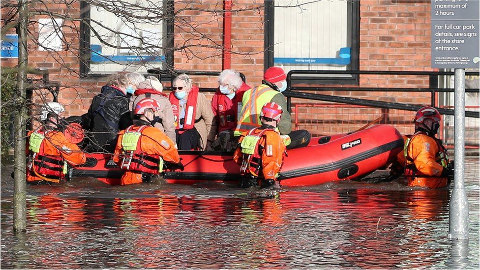 Firefighters transporting people in dinghy