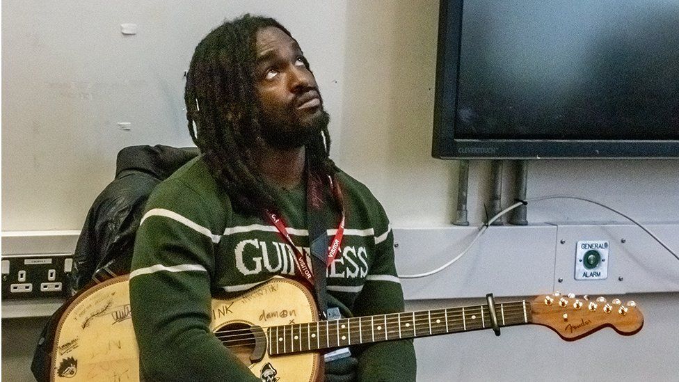 Hak Baker sat with a guitar in HMP Isis.