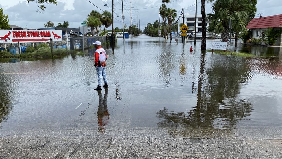 Фотография мужчины, стоящего посреди затопленной улицы в Гудзоне