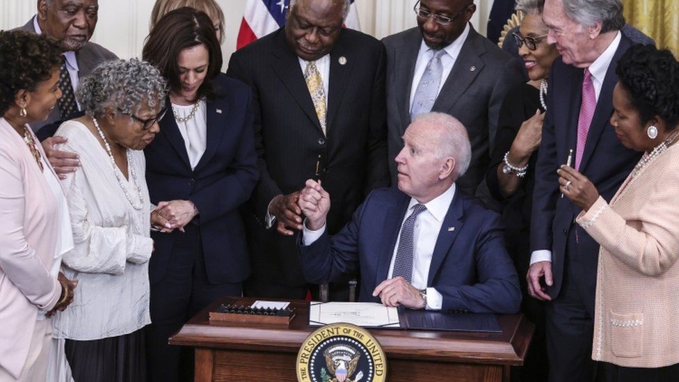 President Joe Biden handles a pen to Opal Lee