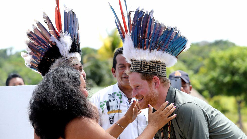 Prince Harry is presented with a headdress by dancers in Sumara, Guyana, during his tour of the Caribbean