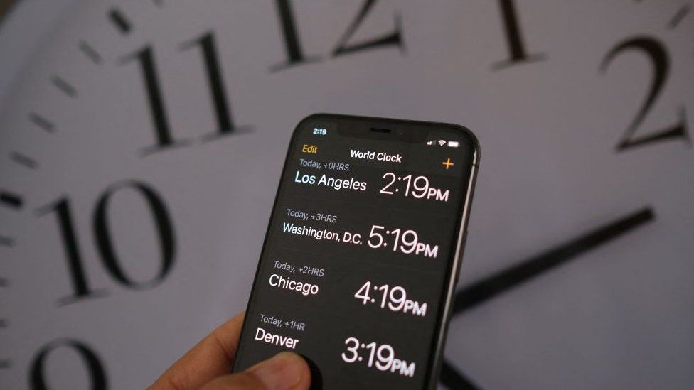 Clock and phone showing daylight savings