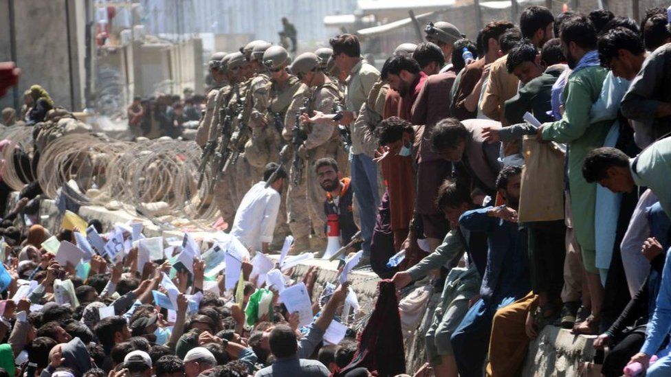 Afghans struggle to reach the foreign forces to show their credentials to flee the country outside the Hamid Karzai International Airport, in Kabul, Afghanistan, 26 August 2021.