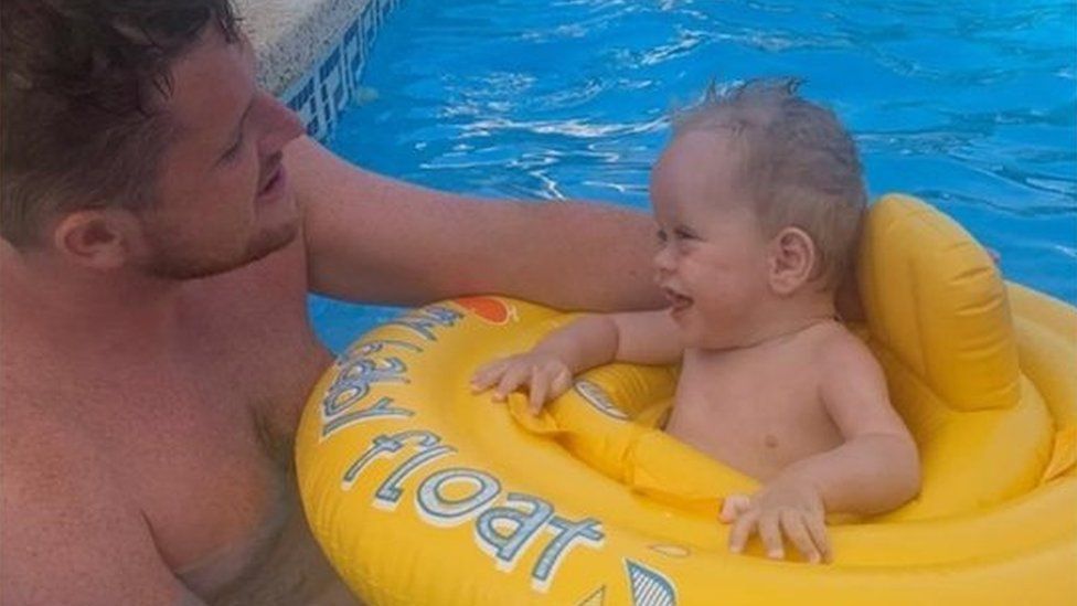 Gilbert Maguire playing with nephew, Asa Burnside, in a swimming pool