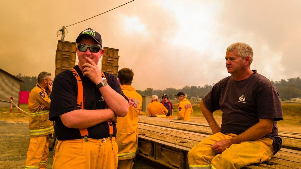 Firefighters take a break from battling a bushfire near the town of Miena in Tasmania