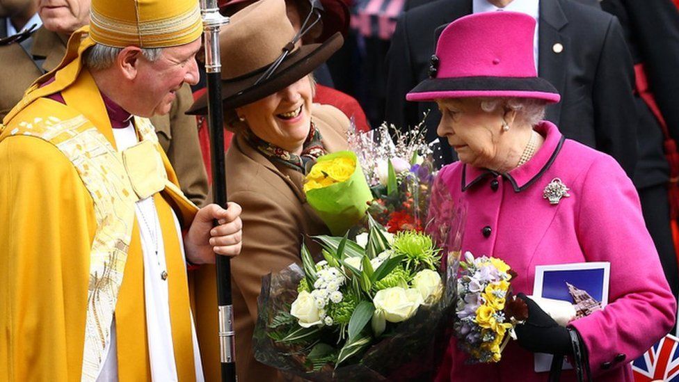 Queen Elizabeth II reacts as she is given some flowers as she visits Leicester Cathedral on 8 March 2012 in Leicester, England.