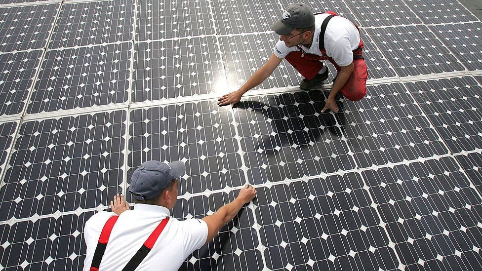 Workers install solar panels in Germany