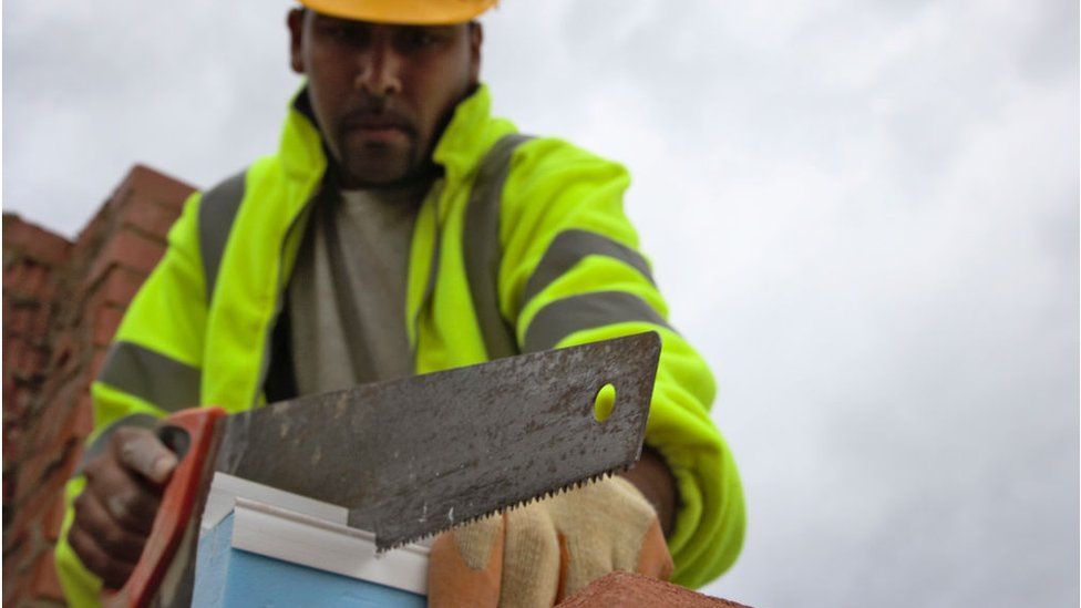 A worker cuts insulation