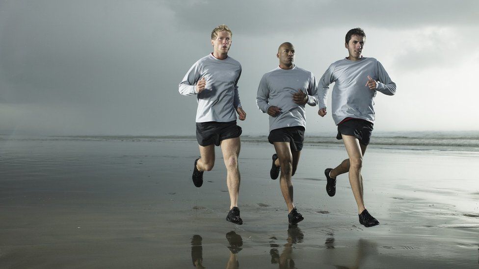 Men jogging on the beach