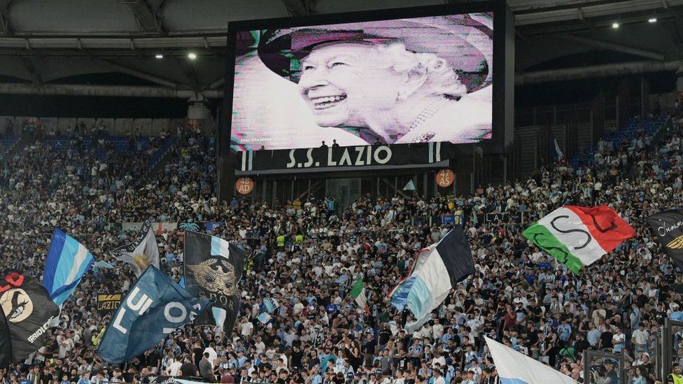 Изображение королевы на большом экране в начале футбольного матча в Риме, Италия