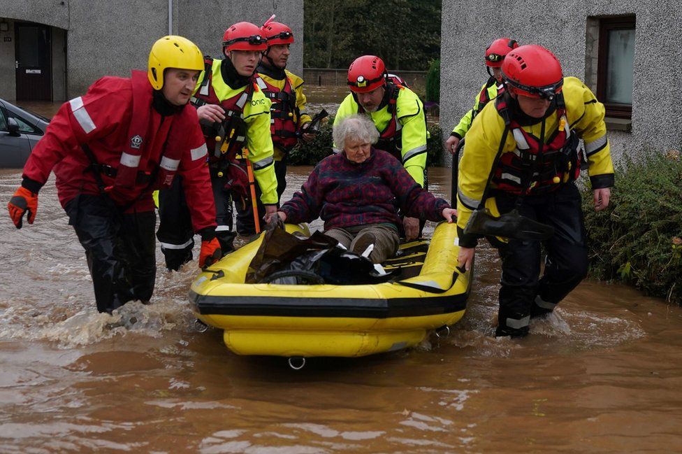 Elderly woman being rescued