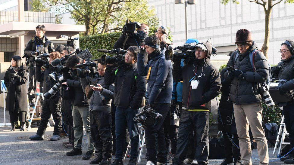 Reporters wait outside the District Court in Tokyo on 8 January