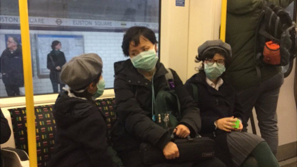 Family wearing facemasks on Tube