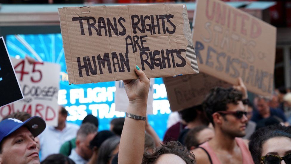 People protest President Trump's announcement he plans to reinstate a ban on transgender individuals from serving