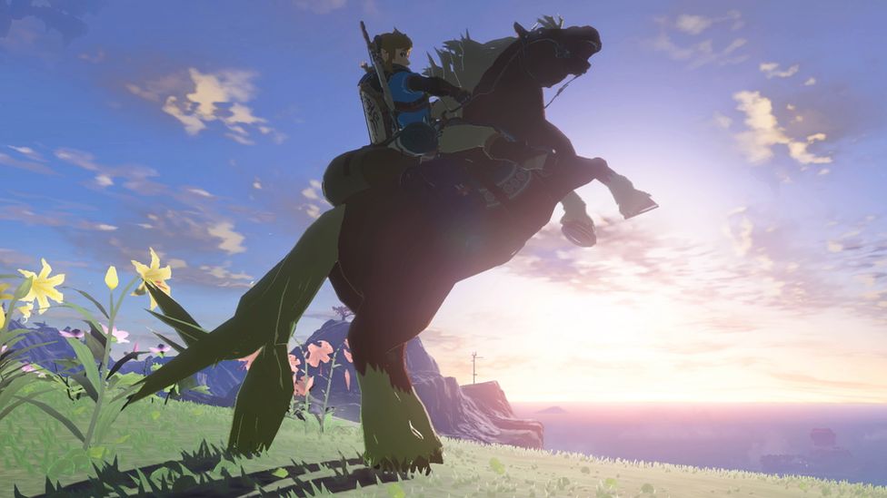 Link, riding his horse, silhouetted against the horizon. The horse is rearing up on its hind legs and the world of Hyrule is visible in the background.