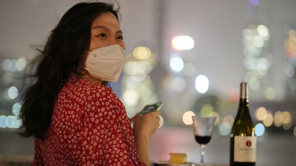 A woman enjoys a glass of wine at midnight on June 1 in Shanghai