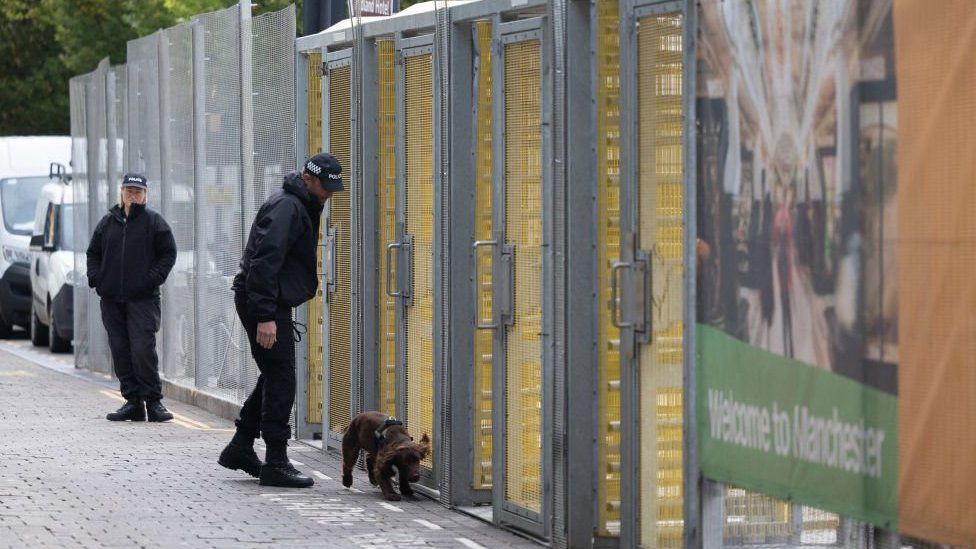 A sniffer dogs checks the perimeter surrounding the Conservative conference