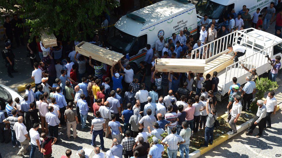 Coffins being carried at the scene of explosion in Suruc, Turkey (20 July 2015)