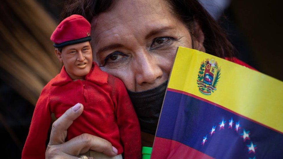 A woman carries a doll of late former president Hugo Chavez during a march in support of the government of Nicolas Maduro in Caracas, Venezuela, 23 January 2024.