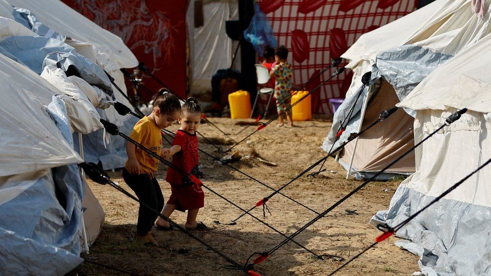 Перемещенные палестинские дети гуляют по палаточному лагерю объекта ООН в Хан-Юнисе на юге сектора Газа (24 октября 2023 г.)