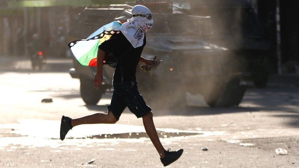A protester runs during a demonstration in Chile