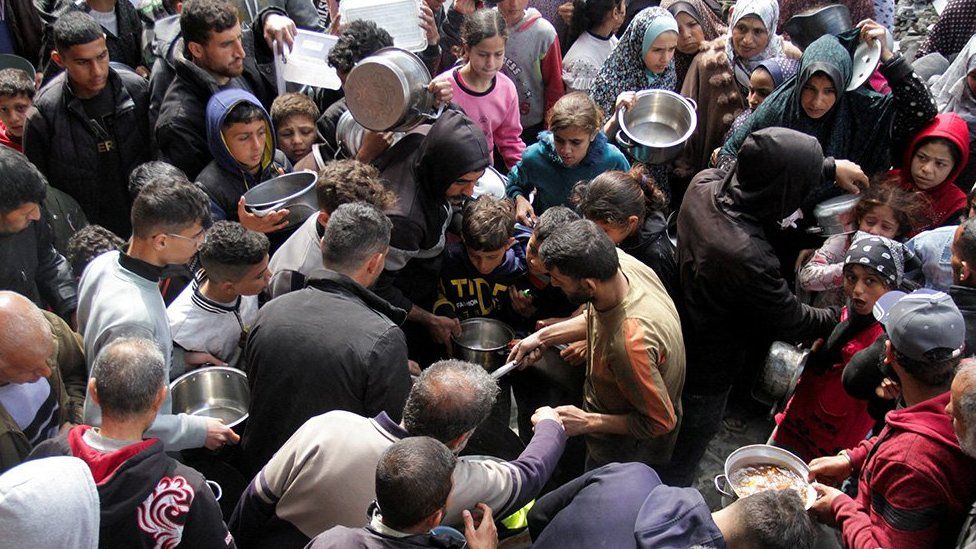 Palestinians gather to receive free food as Gaza residents face crisis levels of hunger, during the holy month of Ramadan, amid the ongoing conflict between Israel and Hamas, in Jabalia in the northern Gaza Strip March 19, 2024.