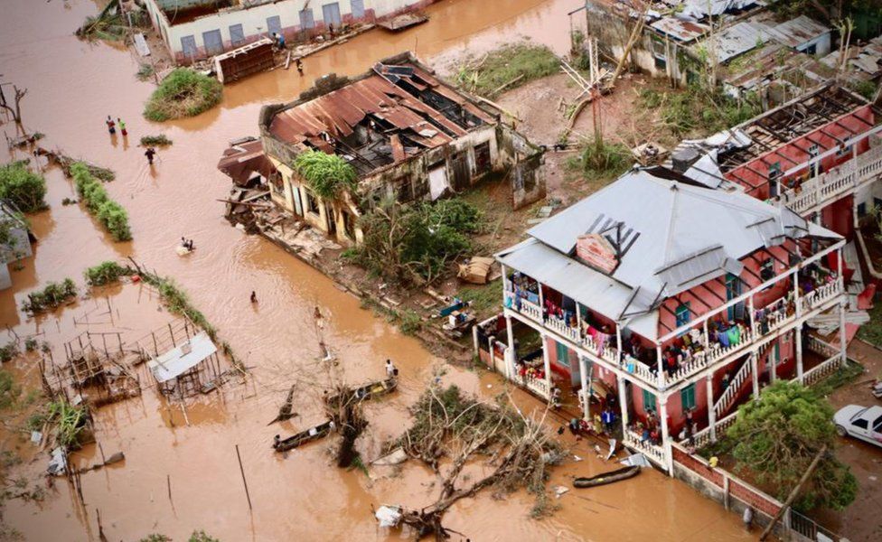 People walk on the flooded street of Buzi, central Mozambique, after the passage of the cyclone Idai - 20 March 2019