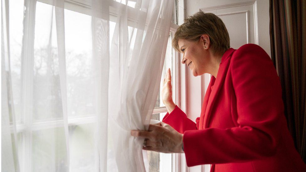 Nicola Sturgeon waving to people gathered outside Bute House in Edinburgh after resigning as Scotland's first minister