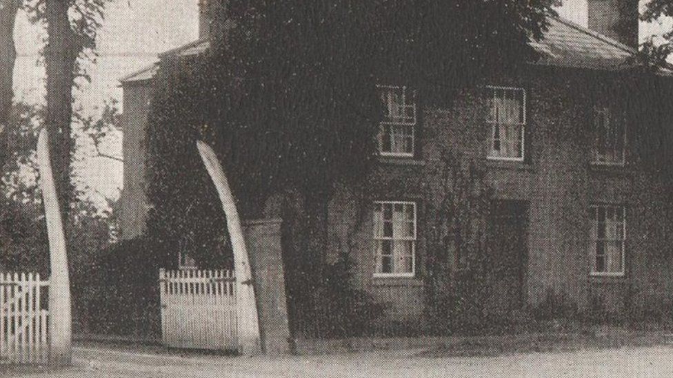 A historic photo of a gateway in March where two whale bones used to stand