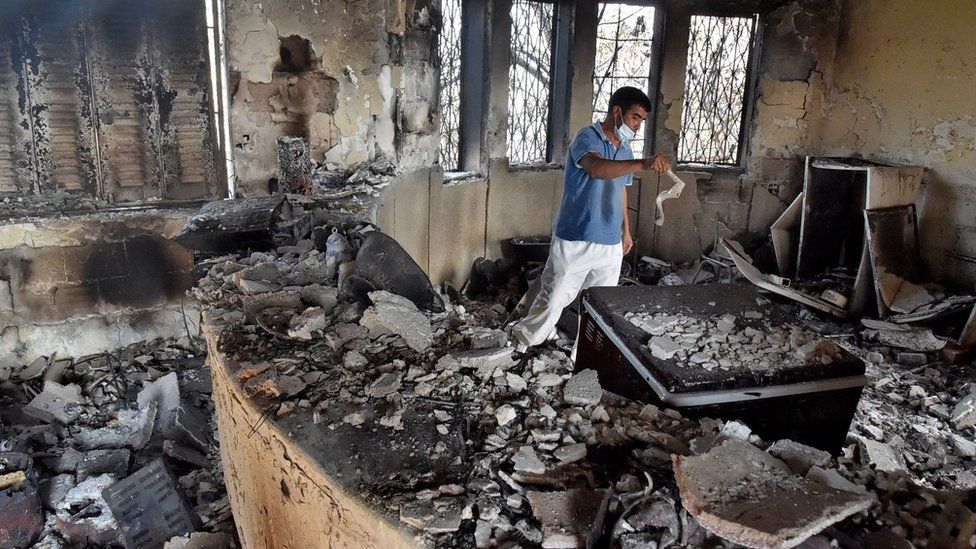Мужчина из Алжира осматривает ущерб в своем доме из-за лесных пожаров в районе Айт-Дауд на севере Алжира 13 августа 2021 г.