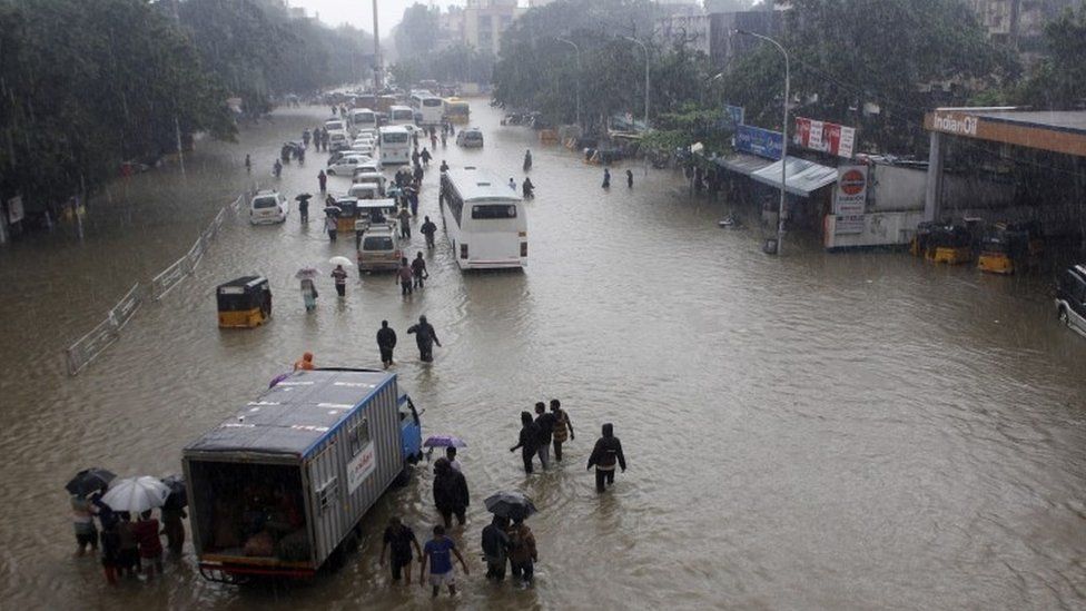 People and vehicles wade through flood waters in Chennai, India, 02 December 2015.