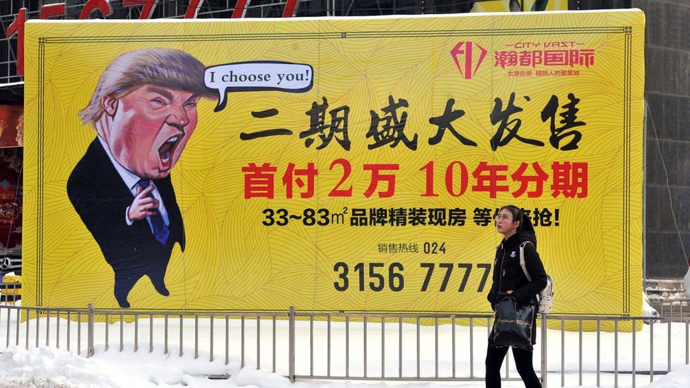 A pedestrian walks past a real estate advertisement featuring a cartoon figure of President Donald Trump in Shenyang in north-eastern China's Liaoning province. 22 Feb 2017.