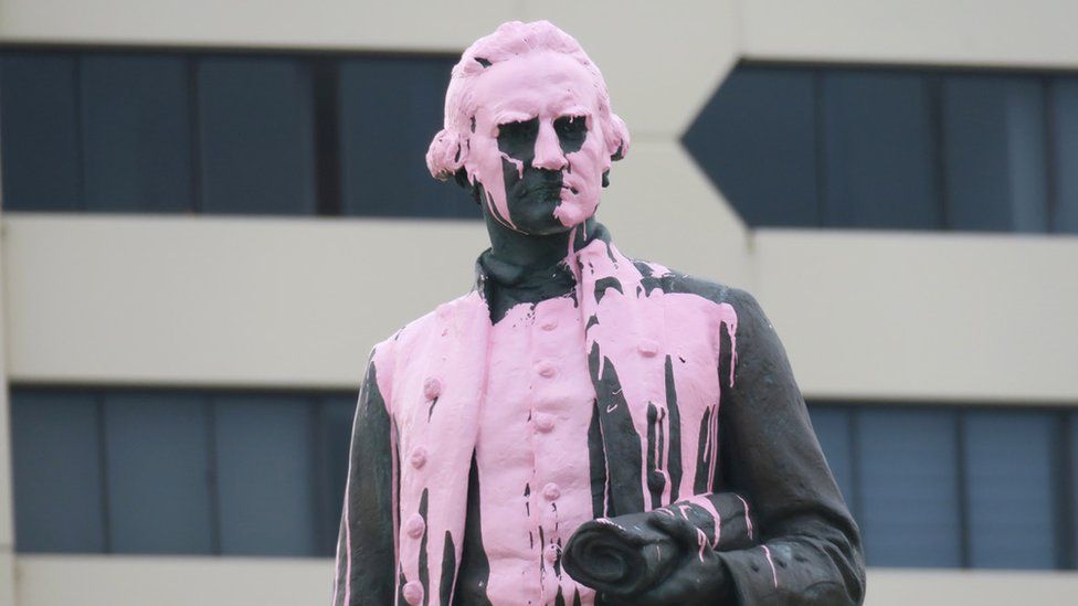 A statue of Captain Cook covered in pink paint