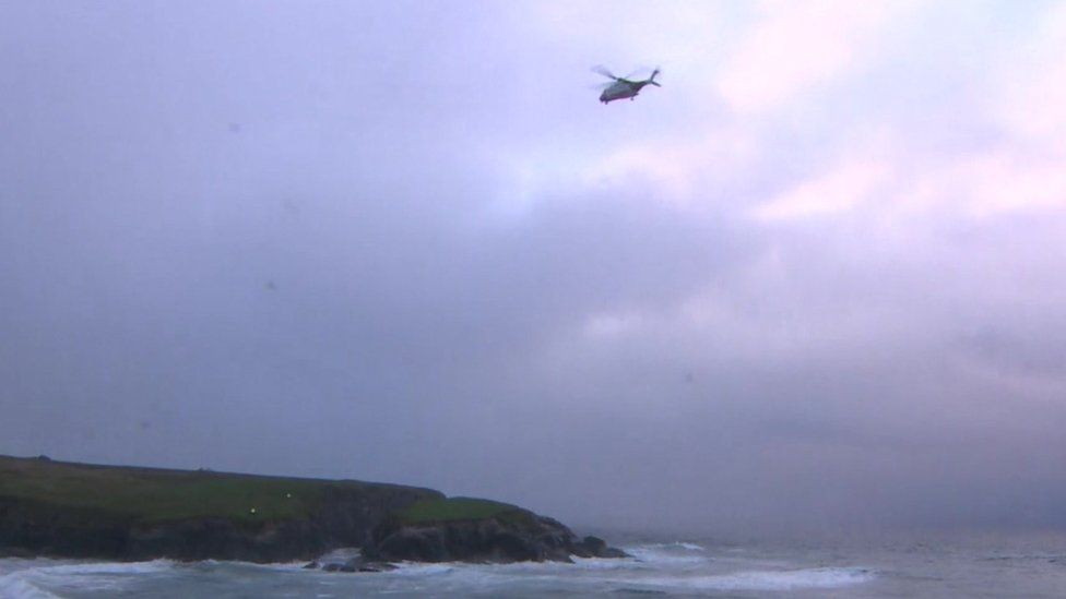 The UK Coastguard search and rescue helicopter from Newquay flies over the coast