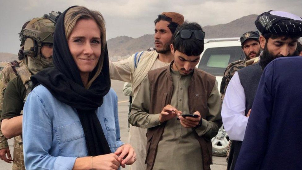 Киви-журналистка Шарлотта Беллис с официальными лицами Талибана разговаривают по айфонам после осмотра международного аэропорта имени Хамида Карзая.
