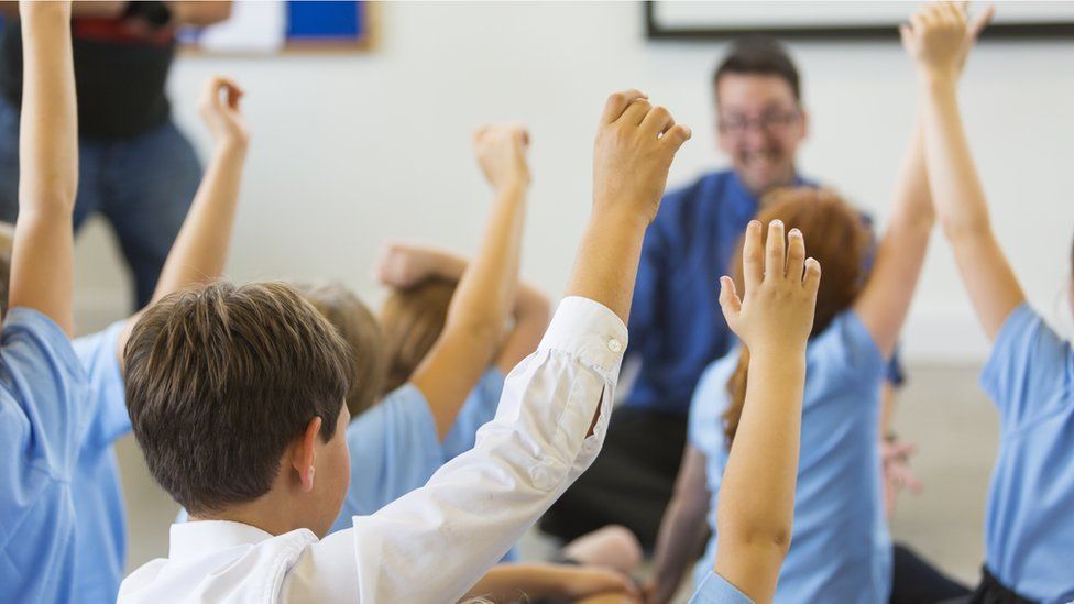 Schoolchildren raising their hands
