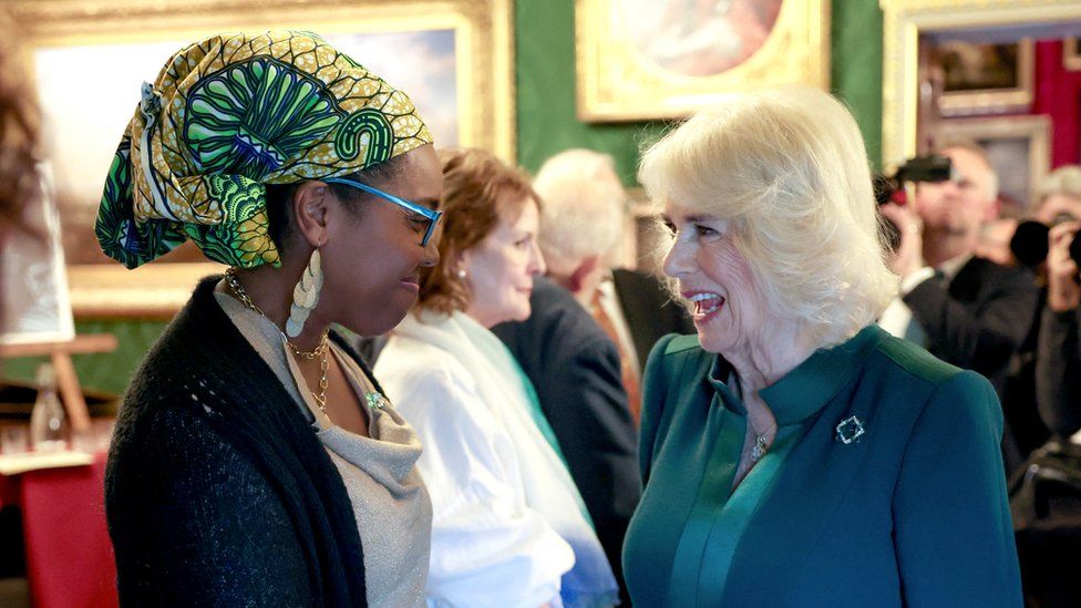 Britain's Queen Camilla smiles and speaks with poet Raquel McKee