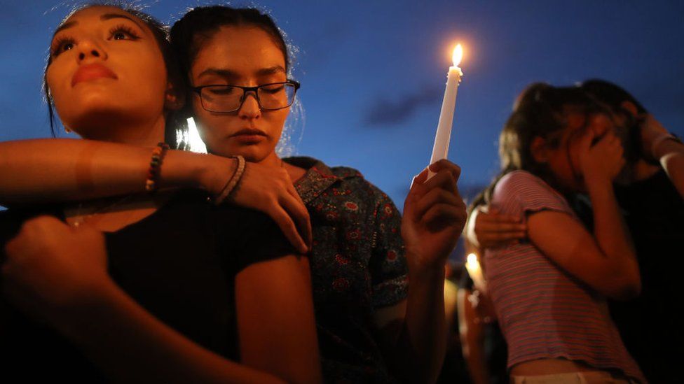 People attend a candlelight vigil at a makeshift memorial for victims of a mass shooting which left at least 22 people dead, on August 7, 2019 in El Paso, Texas