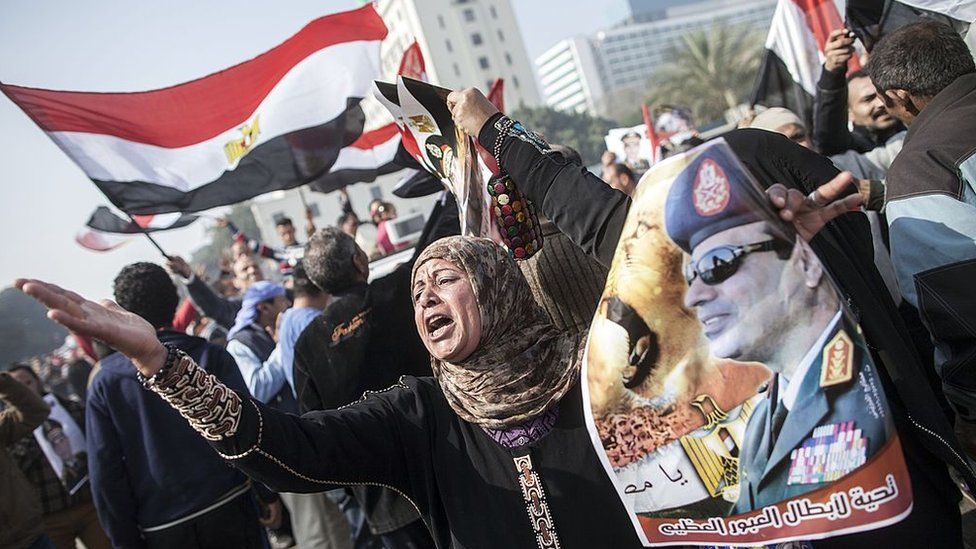 An Egyptian government supporter holds up a poster of Abdul Fattah al-Sisi at a rally in Cairo on the third anniversary of the revolution on 25 January 2014