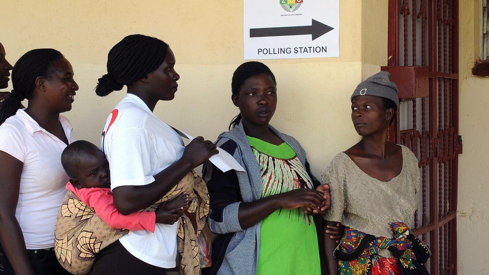 Voters queue at a polling station in 2013