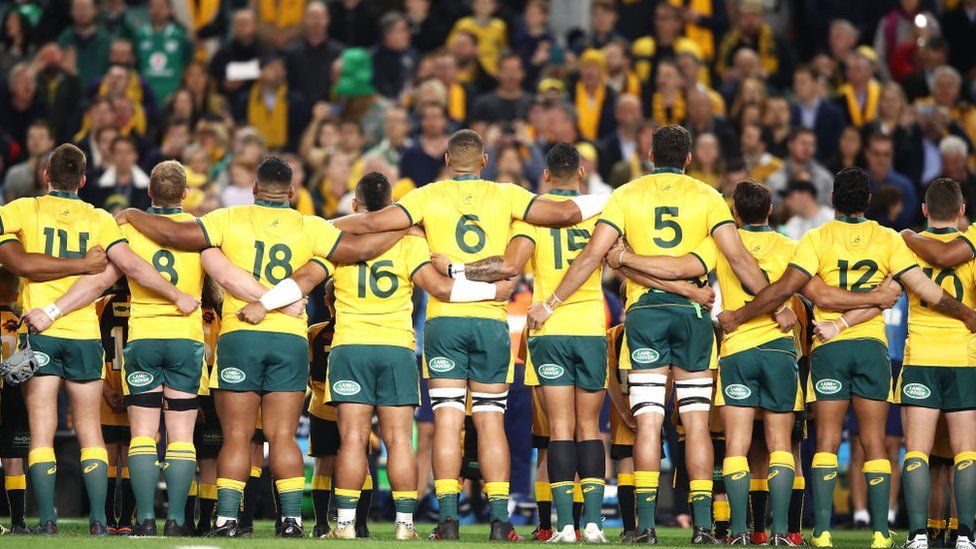 Back view of the Australia's rugby team linking arms and singing the anthem at a test game