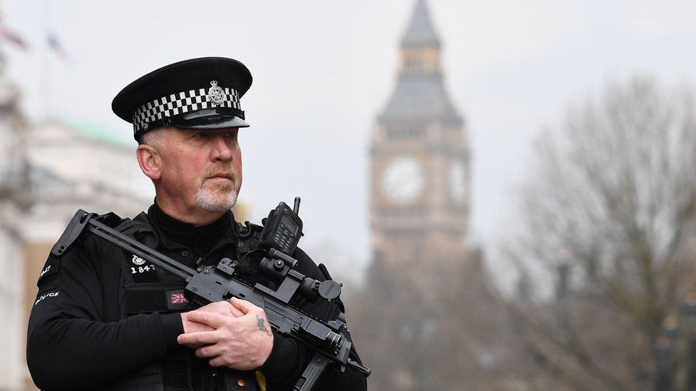 An armed police officer patrols by a security cordon set up along Whitehall by the Houses of Parliament on March 23, 2017 in London.