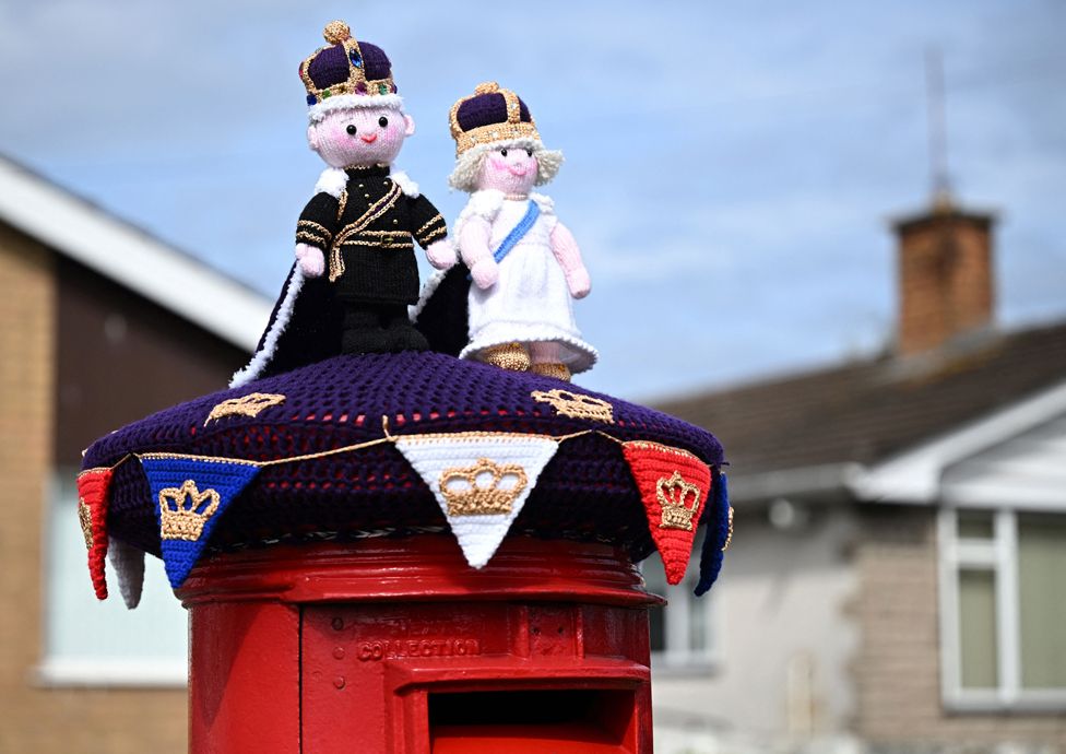 A knitted King Charles and Britain's Camilla, Queen Consort displayed on a postbox in Rhyl, Wales.