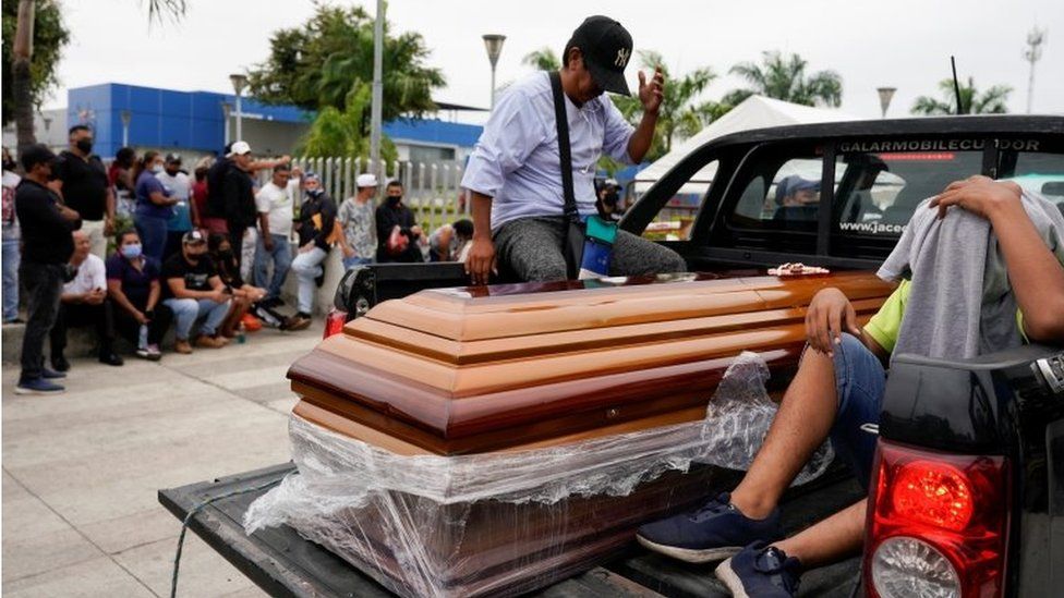 A casket is carried by a pickup truck as people gather outside the judicial police station after prisoners were killed and injured at the Penitenciaria del Litoral prison, in Guayaquil, Ecuador November 14, 2021.