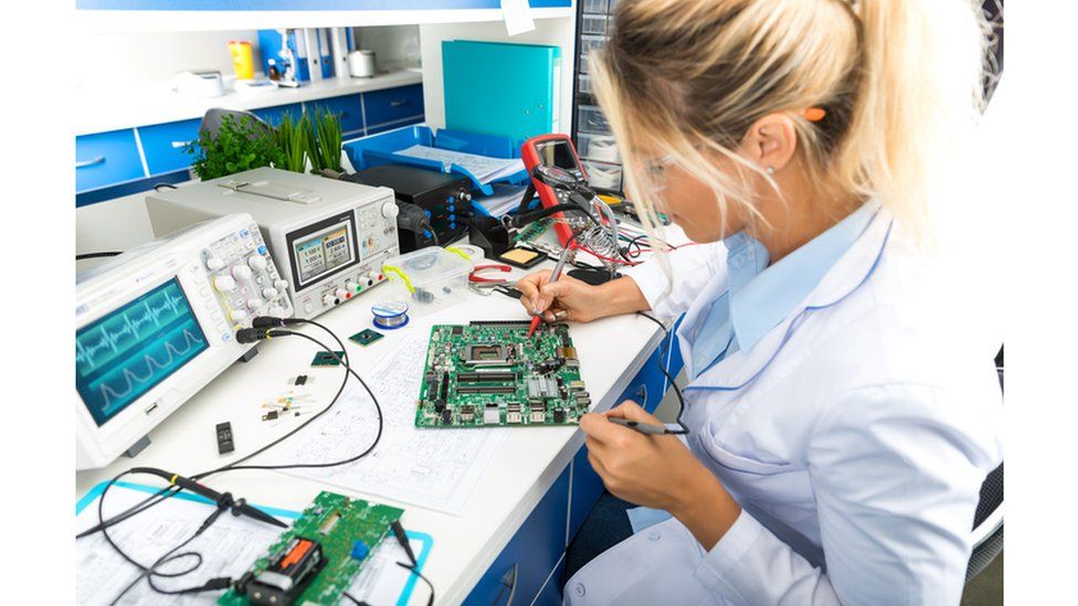 A female electronic engineer testing computer motherboard in laboratory
