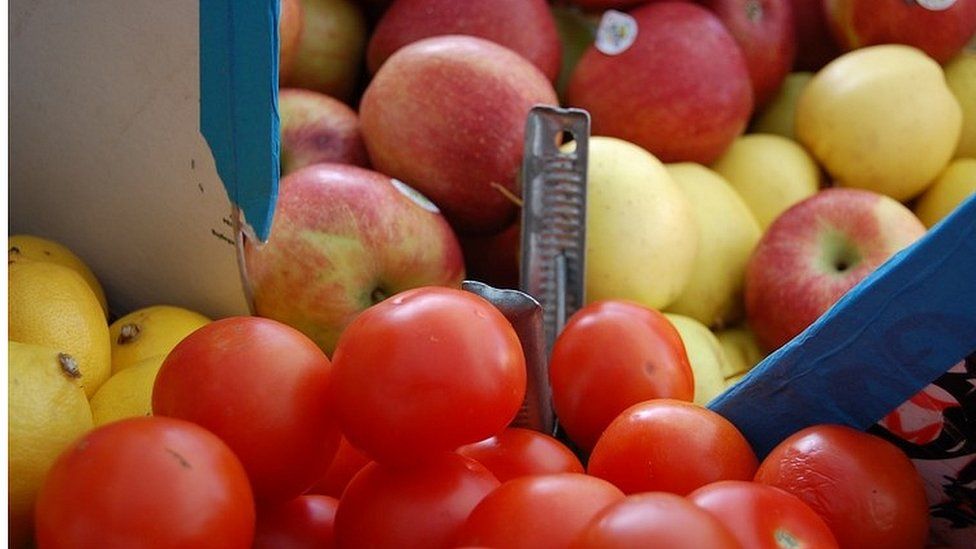 Tomatos and apples on sale at a greengrocer's stall