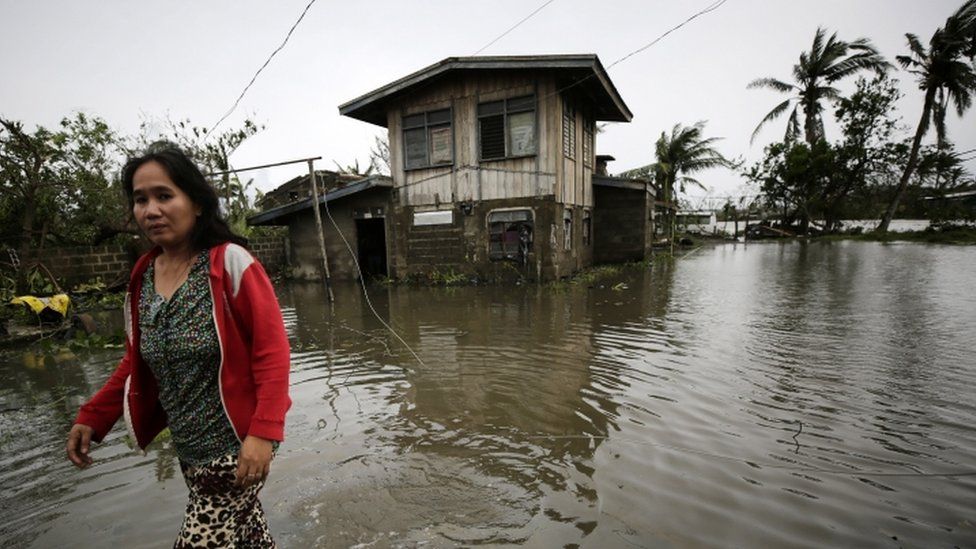 A Filipino villager wades through flood water in the typhoon-hit town of Baggao